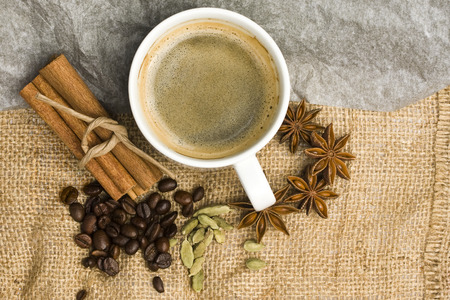 cup of coffee on a piece of burlap coffee beans and spicesの写真素材