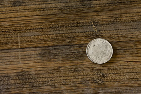 vintage American silver dollar lying on an oak boardの写真素材