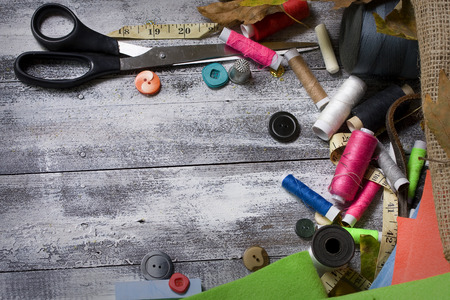 background is with sewing accessories on the rough wooden badly painted tableの写真素材