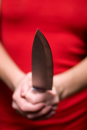The girl who is holding knife in his hand and prepared to attack