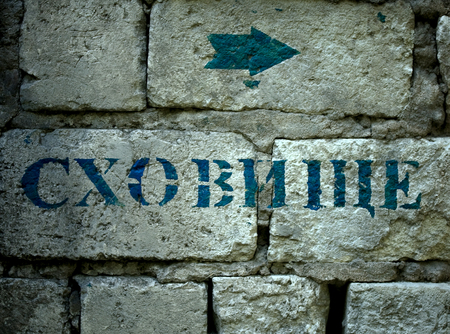 The realities of the war in Ukraine. Pointer bomb shelter in the peaceful Ukrainian city in the event of continued enemy aggression. The inscription on the Ukrainian language Bomb Shelterの写真素材