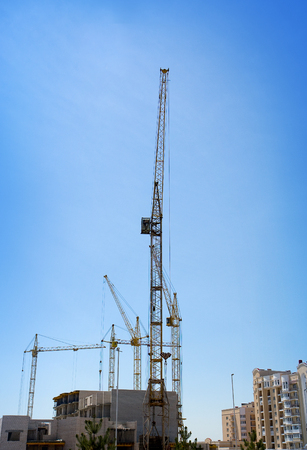 Several tower cranes build a mult storey houseの写真素材