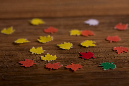 small paper maple leaves on an old wooden boardの写真素材