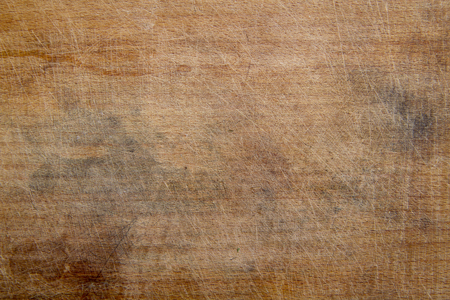 rough wooden kitchen cutting board all in scratches and stains from frequent useの写真素材
