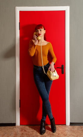 Young red-haired girl talk on the phoneの写真素材