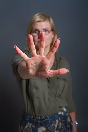 Adult woman shows stopping or prohibiting gesture with handの写真素材