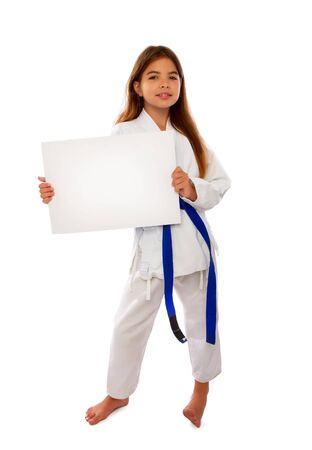 karate girl with a blue belt and a white kimono is holding a blank sheet of paper with a place for textの写真素材