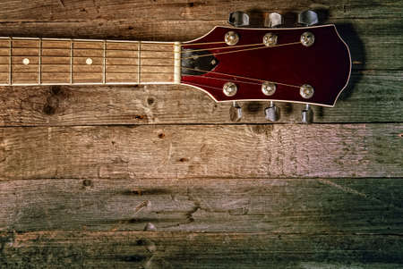 Beautiful old classical acoustic guitar close-up on a wooden backgroundの写真素材