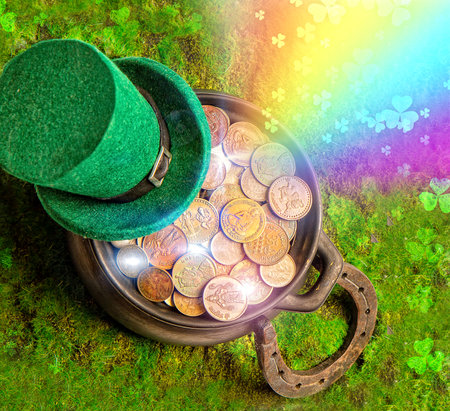 Leprechaun hat and horseshoe lie on green grass with rainbow and clover leaves and treasure potの写真素材