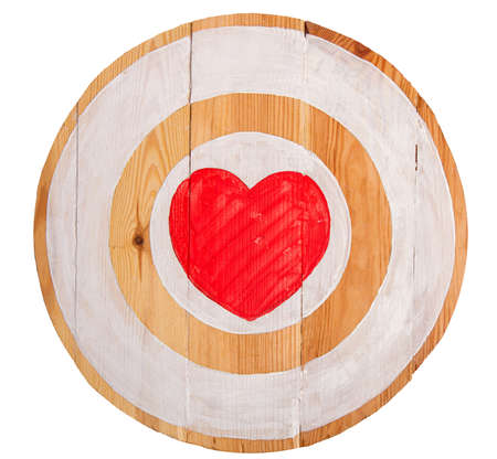 Vintage homemade wooden round target with red heart in center on white backgroundの写真素材