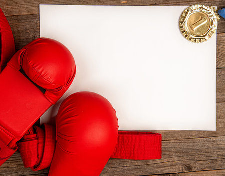 An empty space for your text with a red belt for karate gloves and a gold medal for first place...