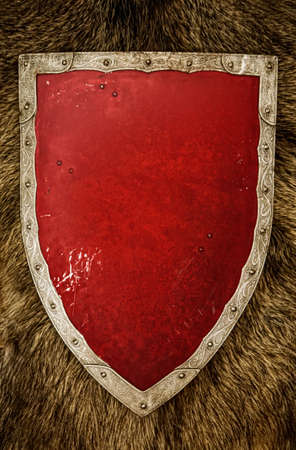 Vintage knightly triangular shield with an empty red centerの写真素材