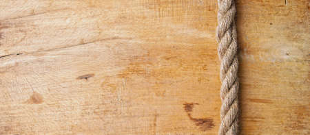 an old rough oak board and a nautical rope on it forming a frame with an empty spaceの写真素材