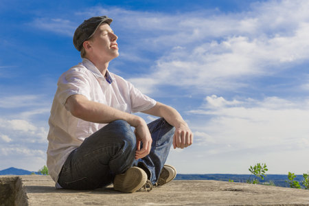 Young man stands in an old castle and suns himselfの写真素材