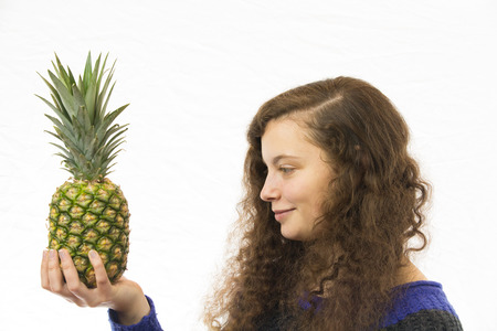 A young pretty woman holding a pineapple in the handの写真素材