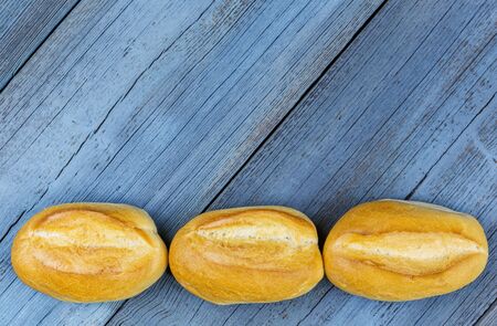 Three buns in a row on blue woodの写真素材