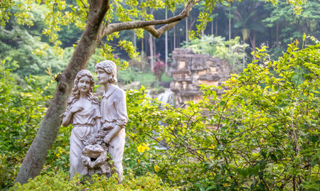 Statues of a couple with a waterfall backgroundの写真素材