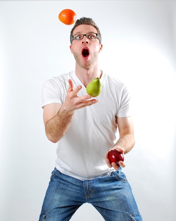 Image of a man juggling fruitの写真素材