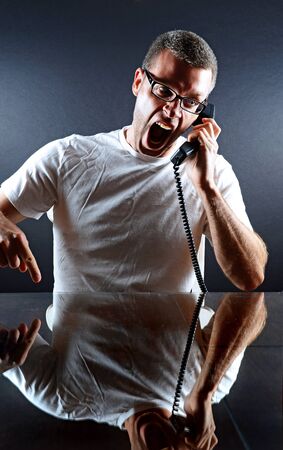 Image of a man yelling in to the phoneの写真素材