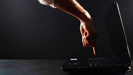 Image of a hand about to touch a laptopの写真素材