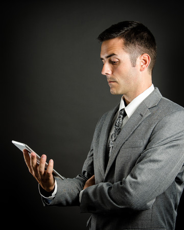 Serious business man holding tabletの写真素材
