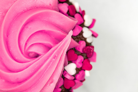 Cupcake with pink icing and heartsの写真素材