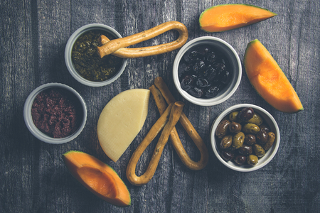 Rustic spread of cheese and bread and olivesの写真素材