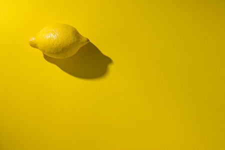 Whole lemon on yellowの写真素材
