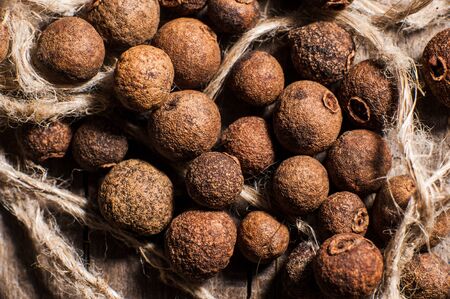 allspice poured on a wooden tableの写真素材