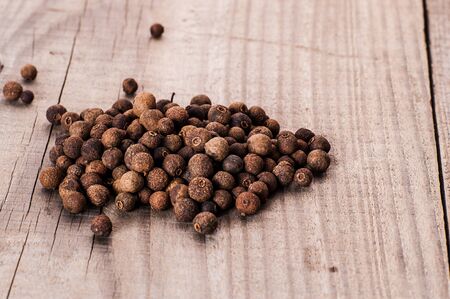 allspice poured on a wooden tableの写真素材