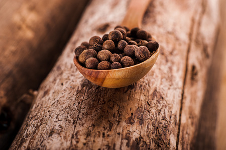 Spoon of pepper on a wooden tableの写真素材