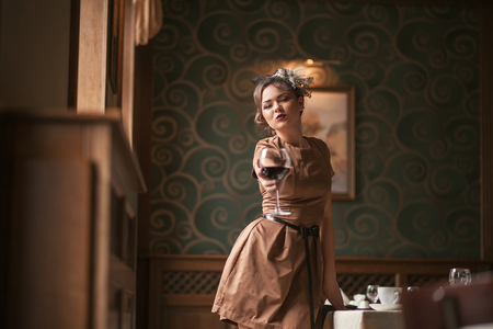 portrait of young female drinking red wineの写真素材