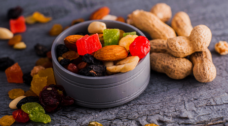 Nuts in a bowl on a wooden background. Dried fruits and nuts.A mixture of dried fruits, candied fruitsの写真素材
