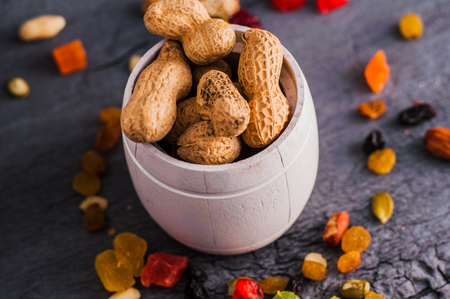 Nuts in a bowl on a wooden background. Dried fruits and nuts.A mixture of dried fruits, candied fruitsの写真素材