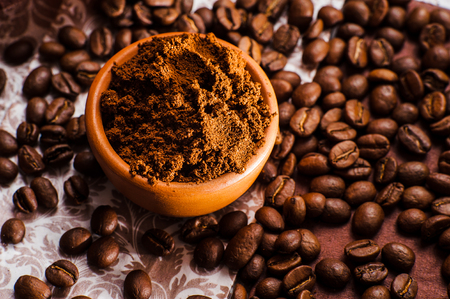 Fresh-ground coffee beans.Coffee beans on wooden texture.A cup of ground coffeeの写真素材