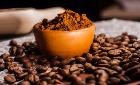 Fresh-ground coffee beans.Coffee beans on wooden texture.A cup of ground coffeeの写真素材