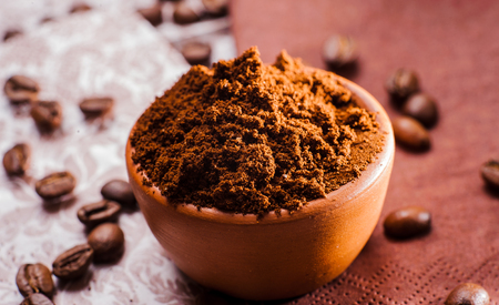 Fresh-ground coffee beans.Coffee beans on wooden texture.A cup of ground coffeeの写真素材