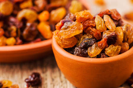 bowl of raisins. raisins on a wooden background.fresh raisinsの写真素材