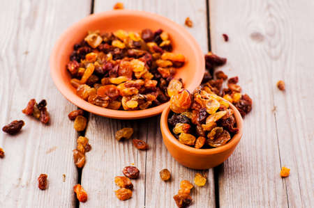 bowl of raisins. raisins on a wooden background.fresh raisinsの写真素材