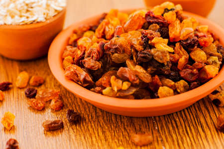 bowl of raisins. raisins on a wooden background.fresh raisinsの写真素材