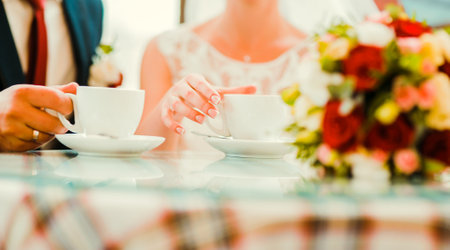 Declarations of love, touching hands, rings.Wedding couple drinking coffee.bride, groomの写真素材