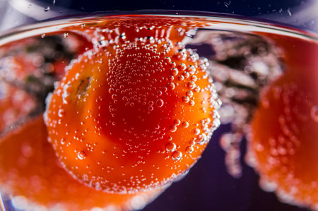 Fruit delicious cherry tomatoes in water. Water drops splashes.の写真素材