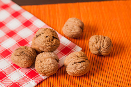 Walnuts on wooden background. Walnuts in a ceramic bowl. Pile of walnuts, closeup.