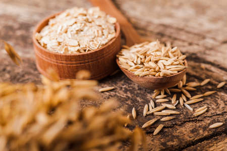 Oat ears of grain on a wooden table, oatmeal. Bounteous harvest. A Healthy fresh Dry Oat mealの写真素材