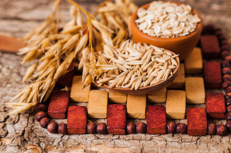 Oat ears of grain on a wooden table, oatmeal. Bounteous harvest. A Healthy fresh Dry Oat mealの写真素材
