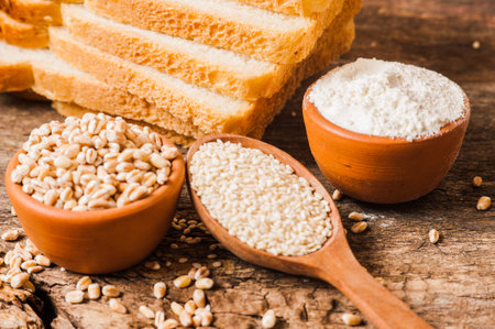 Photo of wheat grains and flour on the wooden table