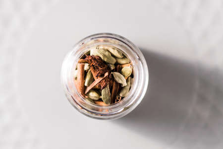 Mug with coffee beans, cinnamon and star anise. Isolated on black vintage background. The concept of aromas and spices, comfort and warmth. flat layの写真素材