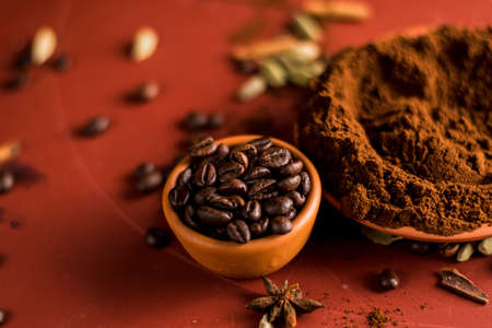 Coffee beans in a bowl and ground coffee on a red backgroundの写真素材