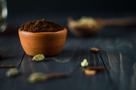 Ground cinnamon in a clay bowl on a dark wooden background. Copy space.の写真素材