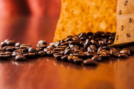 Background of ground coffee texture. Coffee beans are scon wooden table. attered on the table.の写真素材